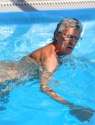 Gay grandpa gives a handsome twink a blowjob and rimjob at the pool